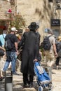 Jerusalem Israel 12-05-2019 View of Jewish orhodox man, from the rear, who is buying for the Sabbath, among the many tourists on t