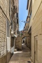 Jerusalem Israel 12-052019 View of a small narrow street with gates and fences that connect the buildings on both sides.