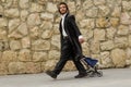 JERUSALEM, ISRAEL, 05.04.2018: Walk of an Orthodox Jewish boy with pace in a black frock coat, with a bale on his head in the