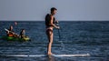 Jesolo beach, images that portrays tourists while they enjoy themselves with attractions created for the sea, canoes, self tables,