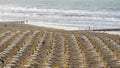 Jesolo, Italy. Beach umbrellas and sun beds at Italian sandy beach. Raws of Yellow and white umbrellas. Aerial view at sunrise