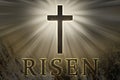 Jesus Christ cross surrounded by light and risen text on a rock background for Easter Royalty Free Stock Photo