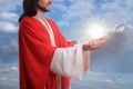 Jesus Christ reaching out his hands and praying against blue sky Royalty Free Stock Photo