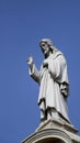 Jesus Christ Statue Atop A Church With Blue Sky In The Background - Savior Concept.