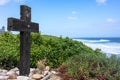 Jesus Christ wood cross. Easter, resurrection concept. Christian wooden cross on a seascape background with sea plants and shrubs Royalty Free Stock Photo