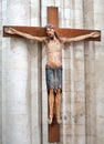 Jesus Christ on a wooden cross monument on a white stone wall of a building Royalty Free Stock Photo