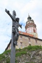 Jesus on cross with tower of palace in Cesky Krumlov behind Royalty Free Stock Photo