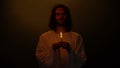 Jesus in crown of thorns with candle praying for people, kindness sins expiation