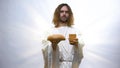 Jesus holding wine and bread on illuminated background, Christian ceremony Royalty Free Stock Photo