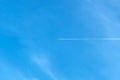 Jet aircraft flying on the high altitude against the backdrop of a clear blue sky. Airplane with two condensation trail on clouds