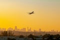 Jet airplane taking off from the Miami Florida airport with city skyline in background during sunrise, sunset. Royalty Free Stock Photo