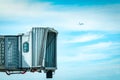 Jet bridge after commercial airline take off at the airport and the plane flying in the blue sky and white clouds. Aircraft Royalty Free Stock Photo
