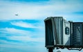 Jet bridge after commercial airline take off at the airport and the plane flying in the blue sky and white clouds. Aircraft Royalty Free Stock Photo