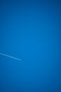 conceptual photo of jet contrails in blue sky - big sky vs tiny airplane Royalty Free Stock Photo
