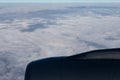 Jet engine aircraft. Blue horizon, view from the airplane`s porthole. The sky in the porthole, white fluffy clouds below. Royalty Free Stock Photo