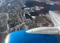 Jet engine and wing seen through airplane window during flight over landscepe. Airplane engine Royalty Free Stock Photo