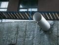 A jet of melt or rainwater flows through an asbestos pipe in a multi-storey building