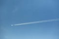 Jet plane and contrail against clear blue sky Royalty Free Stock Photo