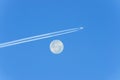 Jet plane flying past the full moon