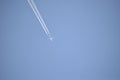 Jet plane leaving contrails flying under a clear blue sky Royalty Free Stock Photo