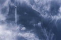 Jet plane and vapor trails going straight up across a cloudy deep blue sky. Royalty Free Stock Photo