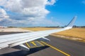 Jet plane window sky view with machine wing between landing taxi way in airport Royalty Free Stock Photo