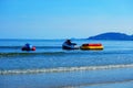 A jet ski boat with air pillows floating on the sea near beach on mountain and blue sky background