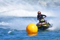 Jet Ski competitor cornering at speed creating at lot of spray. Royalty Free Stock Photo