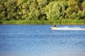 Jet ski watercraft driver driving waterbike in river on seacoast background making splashes. On green Royalty Free Stock Photo