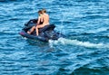 Jet ski with a young European woman and a man, racing across the Baltic Sea