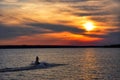 Jet skier driving off into the sunset