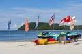 Jet skis on the sunny beach with flags of different countries on Langkawi Island.