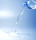 A jet of sparkling water escaping from the bottle. White blue tone image.