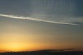 Jet stream blowing away in the sky as the sun sets Royalty Free Stock Photo