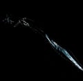 Jet of transparent water with small drops and splashes on a black background Royalty Free Stock Photo