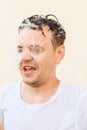 Jet of water, water splash flying in man male face. Shocked young caucasian european white man with open mouth, portrait, mental Royalty Free Stock Photo