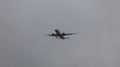 JetBlue Airbus A220 aircraft flying through the sky on a grey cloudy day