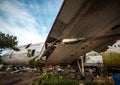 Jetliner Being Cut To Pieces For Recyling Purpose at Airplane Graveyard Under The Blue Cloudy Sky. Under Wing Part Being Dismantle Royalty Free Stock Photo