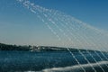 Jets of water from the fountain overflow in the sun and fall into the lake. In the background of the photo you can see the lake Royalty Free Stock Photo