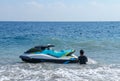 Jetski floating on blue sea water. Strong power watercraft is waiting customers. Young Indonesian holding a jetbike near the shore