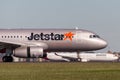 Jetstar Airways Airbus A320 airliner landing at Sydney Airport with a Qantas aircraft in the background. Royalty Free Stock Photo