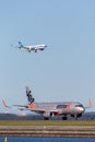 Jetstar Airways Airbus A320 airliner at Sydney Airport with a China Southern Airbus A330 on approach in the background. Royalty Free Stock Photo