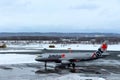 Jetstar plane getting ready for take off at Chitose airport on a snowy day Sapporo