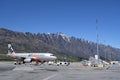Jetstar plane waiting on the runway at Queenstown airport, Remarkables moutains in the background