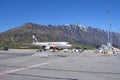 Jetstar plane waiting on the runway at Queenstown airport, Remarkables moutains in the background