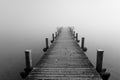 Jetty in the fog. Mystical foggy landscape at the lake. Royalty Free Stock Photo