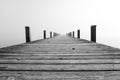 Jetty in the fog. Mystical foggy landscape at the lake. Royalty Free Stock Photo