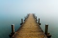 Jetty in the fog. Mystical foggy landscape at the lake. Royalty Free Stock Photo