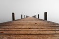 Jetty in the fog. Mystical foggy landscape at the lake. Royalty Free Stock Photo