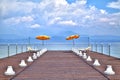 On a jetty at the Lake Garda glowing luminous orange-colored sunshades Royalty Free Stock Photo